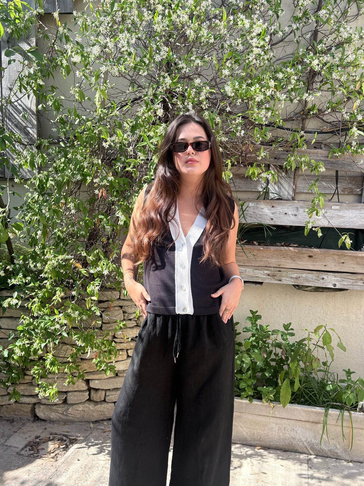 Gilet bicolore noir et écru à encolure en V, porté avec un pantalon noir