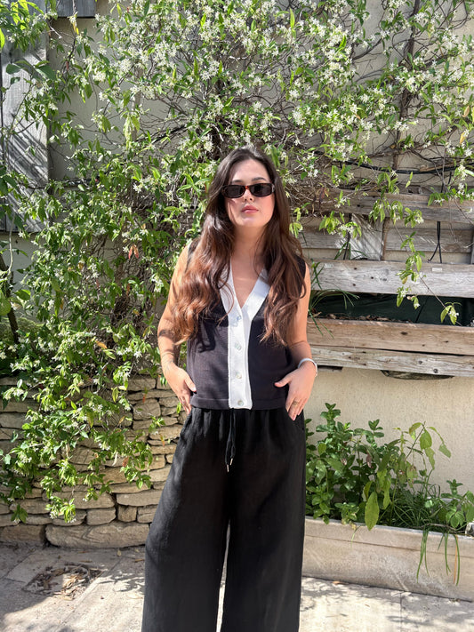 Gilet bicolore noir et écru à encolure en V, porté avec un pantalon noir